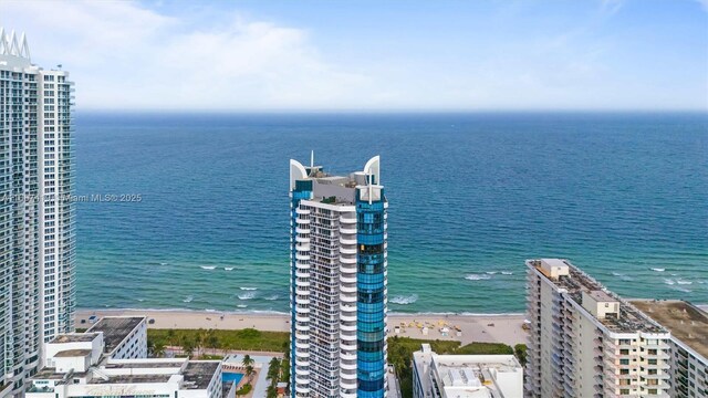 birds eye view of property featuring a water view and a beach view