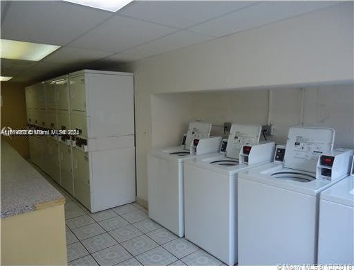 laundry room featuring light tile patterned floors and washing machine and clothes dryer