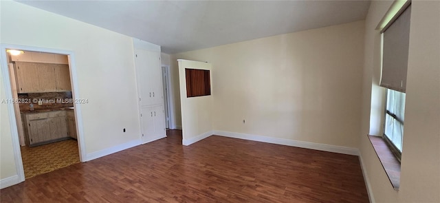 empty room featuring lofted ceiling and dark hardwood / wood-style floors