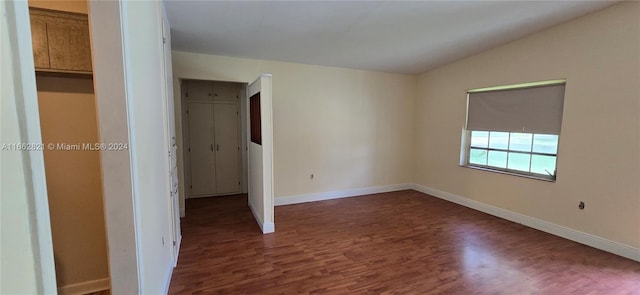 unfurnished room with vaulted ceiling and dark hardwood / wood-style flooring