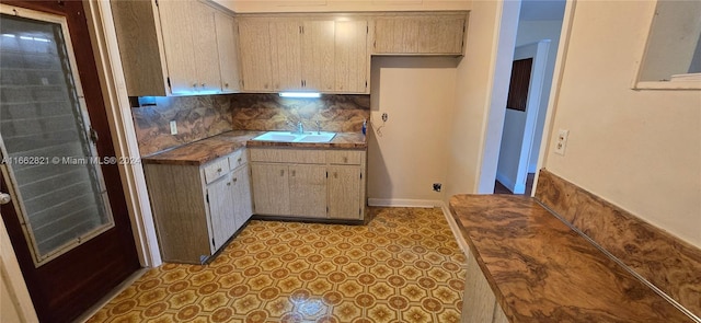 kitchen with butcher block counters, light brown cabinets, tasteful backsplash, and sink