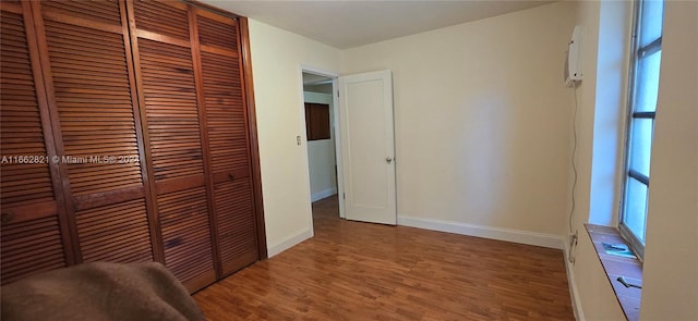 unfurnished bedroom featuring a closet and hardwood / wood-style floors