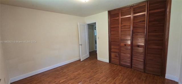 unfurnished bedroom with wood-type flooring and a closet