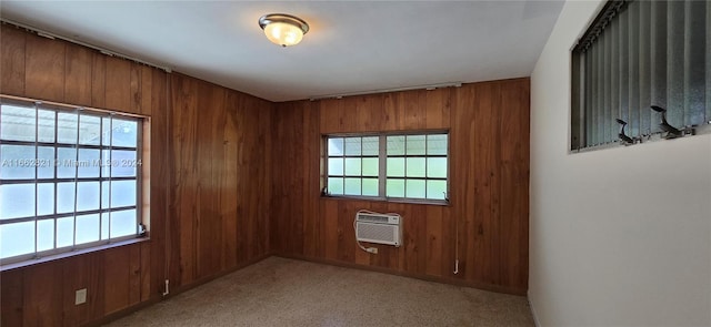 empty room with wooden walls, a wall mounted AC, and light colored carpet