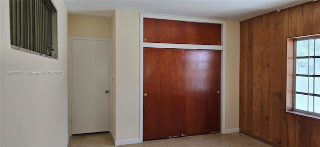 unfurnished bedroom with wooden walls and a closet