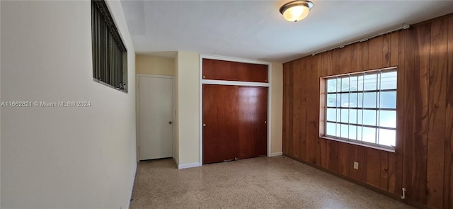 unfurnished bedroom with wood walls