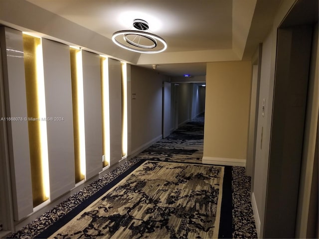 hall featuring dark colored carpet