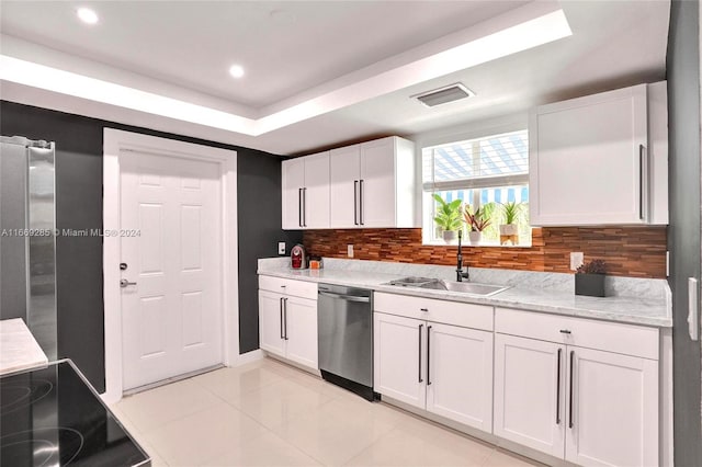 kitchen featuring decorative backsplash, white cabinetry, dishwasher, light tile patterned floors, and sink