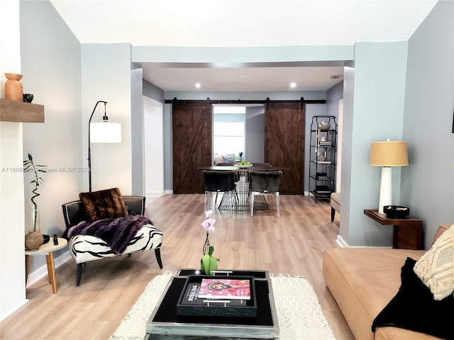 living room with light hardwood / wood-style floors and a barn door