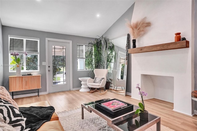 living room with light hardwood / wood-style flooring and vaulted ceiling