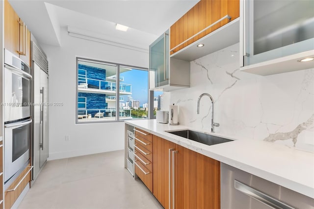 kitchen with tasteful backsplash, appliances with stainless steel finishes, and sink