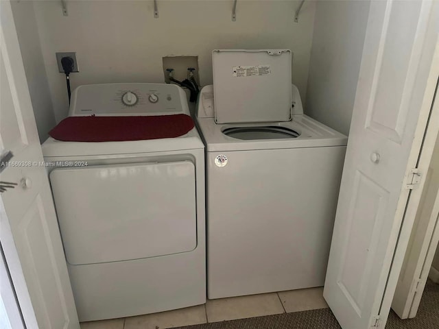 washroom featuring light tile patterned flooring and washer and dryer