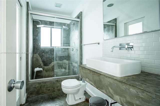 full bathroom featuring toilet, tasteful backsplash, shower / bath combination with glass door, sink, and tile walls