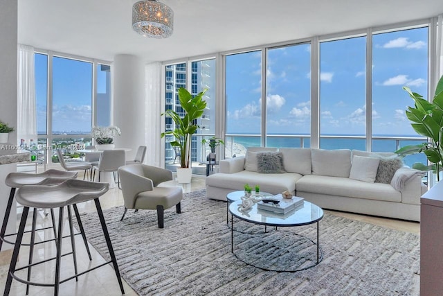 living room with a water view, a wall of windows, and plenty of natural light