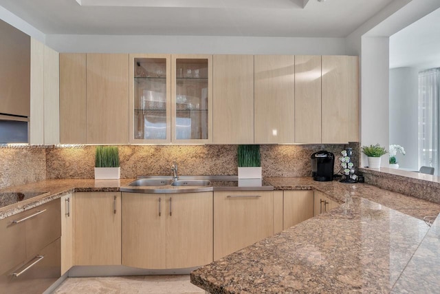 kitchen featuring light brown cabinetry, sink, kitchen peninsula, and decorative backsplash