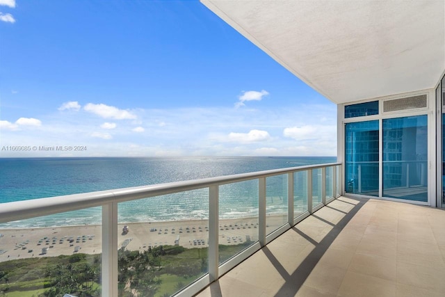 balcony with a beach view and a water view