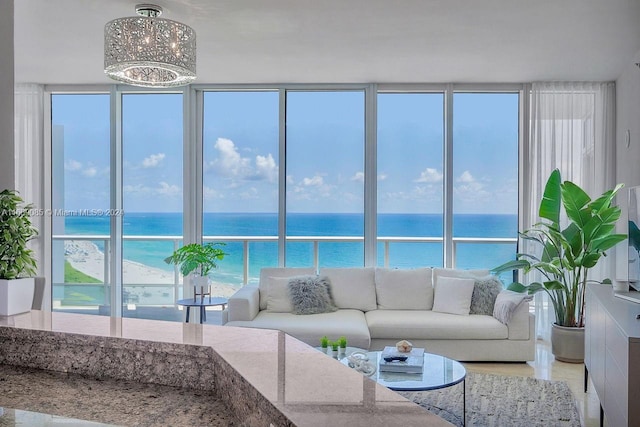 living room with a beach view, a chandelier, and a water view