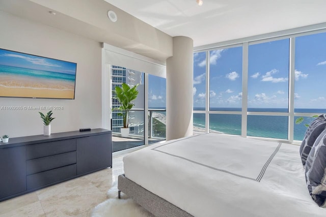 bedroom with a water view and expansive windows