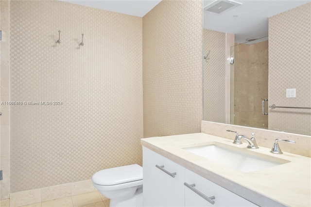 bathroom with tile patterned flooring, walk in shower, vanity, and toilet