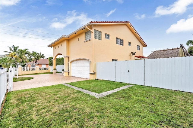 rear view of property with a garage and a lawn