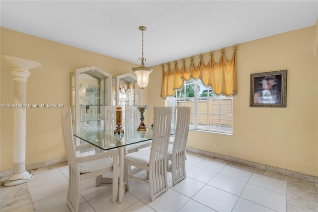 unfurnished dining area with decorative columns and light tile patterned floors