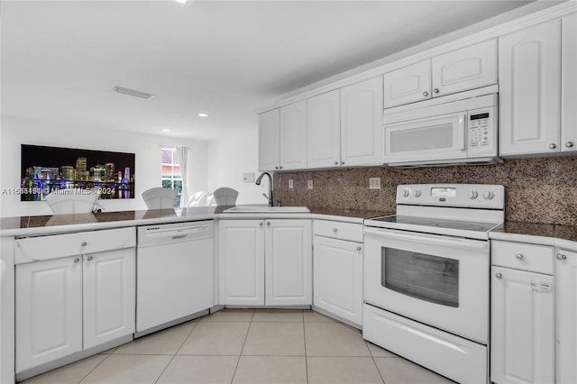 kitchen with light tile patterned floors, sink, white appliances, and white cabinetry