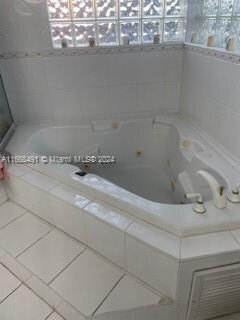 bathroom featuring tile patterned flooring and a relaxing tiled tub