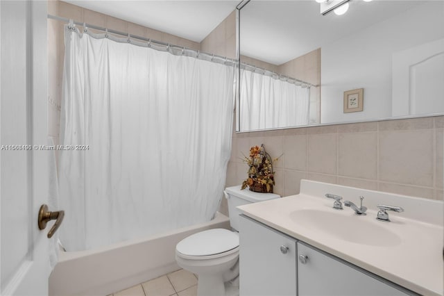 full bathroom featuring tile walls, tile patterned flooring, shower / tub combo with curtain, vanity, and toilet