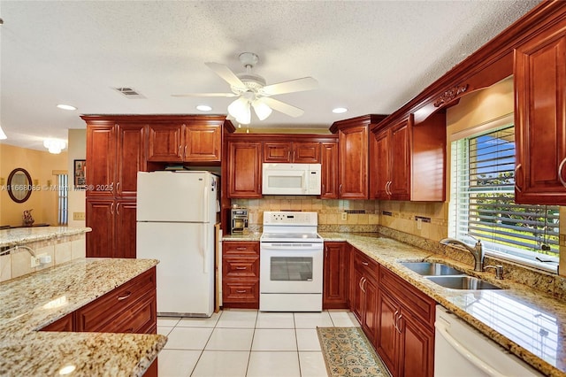 kitchen with sink, backsplash, light tile patterned floors, light stone counters, and white appliances