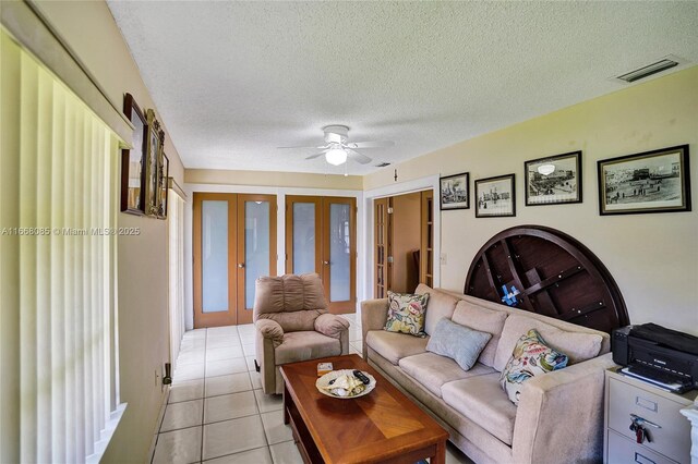 dining room with ceiling fan with notable chandelier, light tile patterned floors, and a textured ceiling