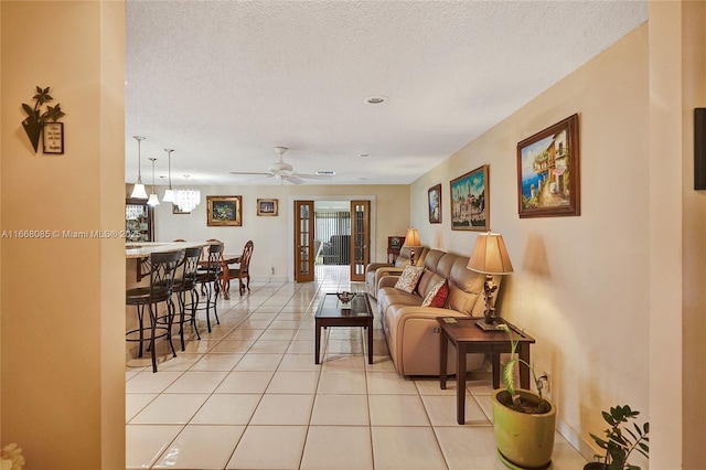 tiled living room with ceiling fan and a textured ceiling