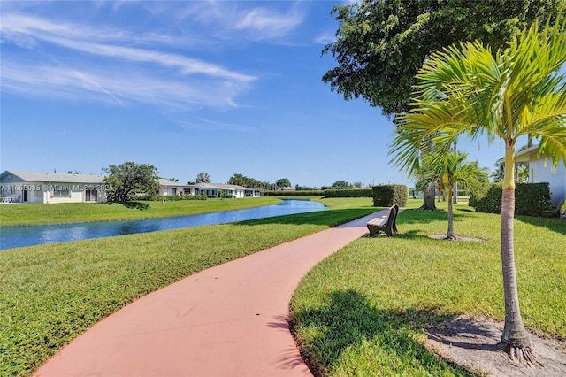 view of home's community featuring a lawn and a water view