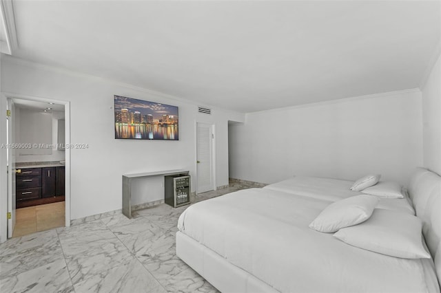 bedroom featuring ornamental molding and connected bathroom