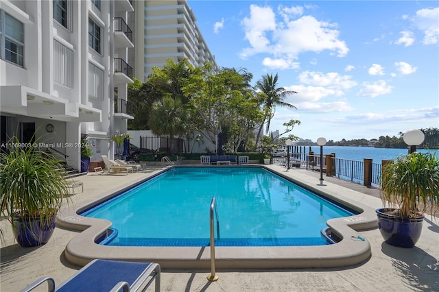 view of pool with a patio and a water view