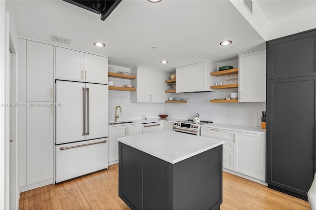 kitchen with light hardwood / wood-style floors, a center island, sink, white cabinets, and white appliances