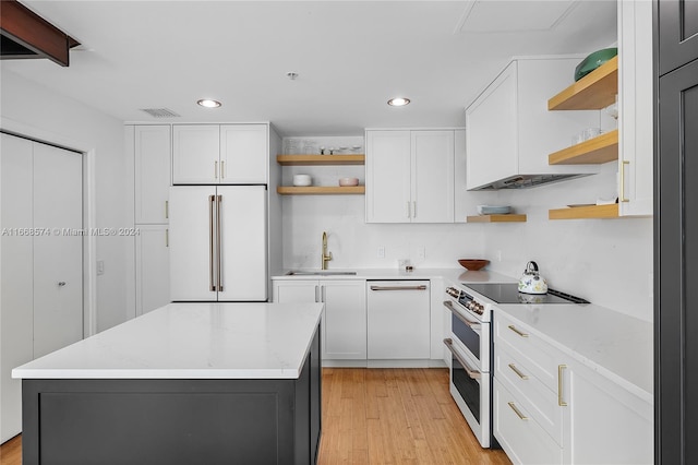 kitchen with white appliances, white cabinetry, sink, and light hardwood / wood-style flooring