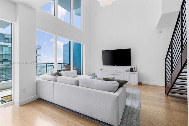 living room with a high ceiling and light hardwood / wood-style floors