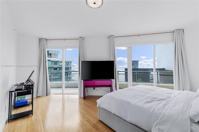 bedroom with multiple windows and hardwood / wood-style floors