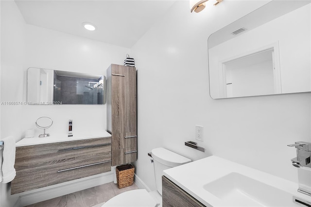 bathroom featuring walk in shower, vanity, and toilet