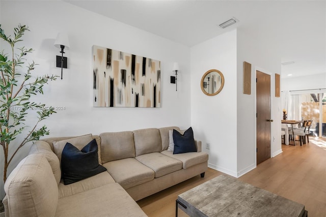 living area featuring light wood-type flooring, baseboards, and visible vents