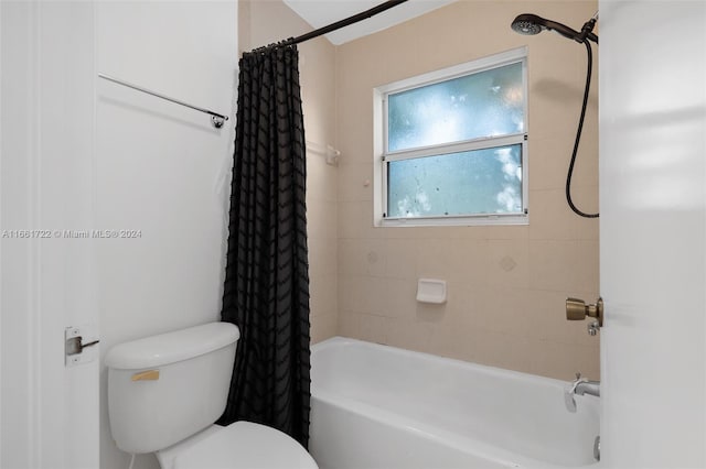 bathroom featuring shower / tub combo with curtain and toilet