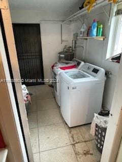 laundry area with light tile patterned flooring and independent washer and dryer