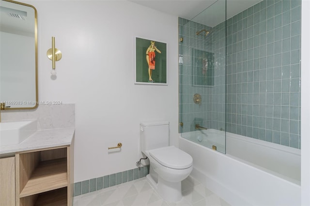 full bathroom featuring vanity, tiled shower / bath combo, toilet, and tile patterned flooring