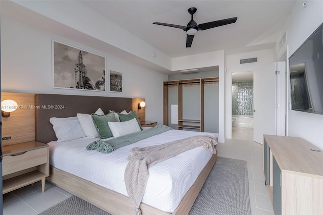 tiled bedroom with ensuite bath and ceiling fan