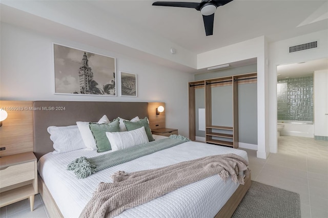 bedroom featuring ceiling fan, light tile patterned floors, a closet, and ensuite bathroom