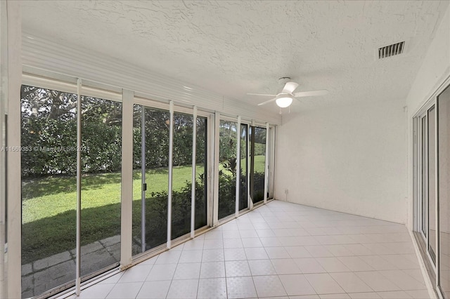 unfurnished sunroom with ceiling fan