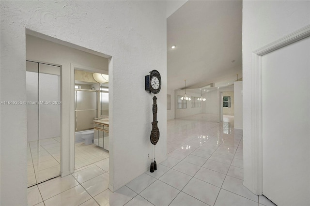 corridor featuring vaulted ceiling and light tile patterned floors