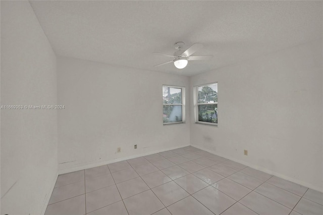 tiled spare room with ceiling fan and a textured ceiling