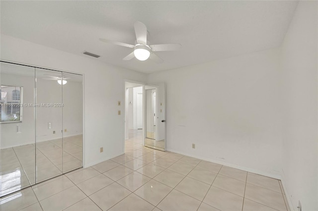 unfurnished bedroom with a closet, ceiling fan, and light tile patterned floors