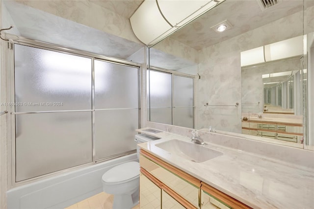 full bathroom with enclosed tub / shower combo, tile patterned flooring, vanity, and toilet